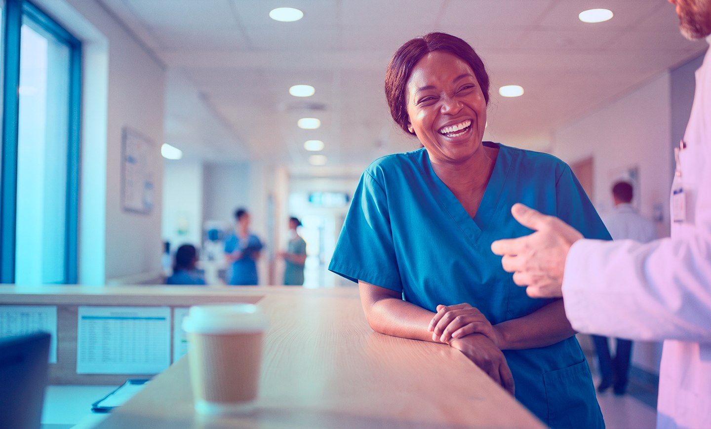 Enfermeira sorrindo conversando com médico